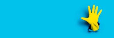 Avuç içinin açık olduğunu gösteren sarı eldiven, parlak mavi arka planda beş parmak. Pankart