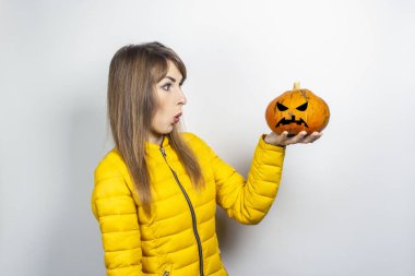 Ted Surat ve arka planda kafasını tutan bir balkabağı eli. Cadılar Bayramı konsepti, sonbahar, kutlama.