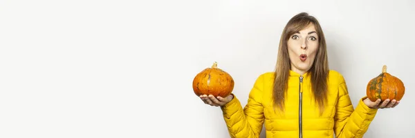 Shocked Young Girl Yellow Jacket Holds Two Pumpkins Light Background — Stock Photo, Image