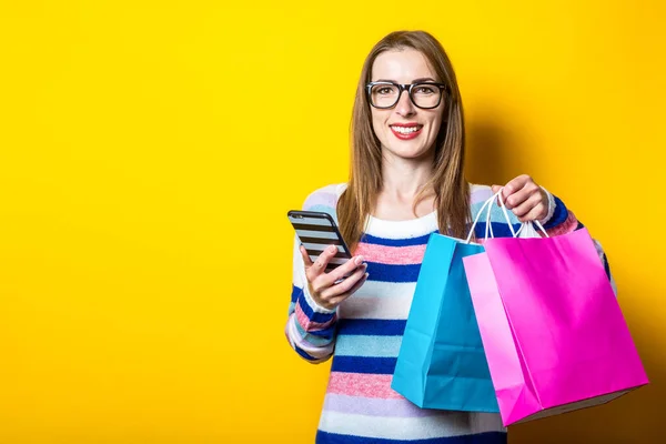 Mujer Joven Sonriendo Sosteniendo Teléfono Bolsas Compras Con Compras Fondo —  Fotos de Stock