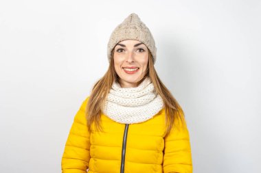 Sarı ceketli ve arka planda şapkası olan genç bir kadın. Güzellik ve moda kavramı, kış, sonbahar. Pankart.