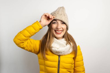 Genç bir kadın arka planda şapkasının altından dışarı bakıyor. Kış konsepti, kış modası, kış kıyafetleri. Komik ruh hali, duygular.