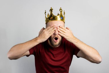 Altın kaplamalı genç bir adam ve gözleri açık bir arkaplanda kapalı. Kavram, kral, şans, kazanç, zenginlik, hayal, amaç, istektir. Pankart.