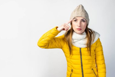 Sarı ceketli ve şapkalı ciddi odaklanmış genç bir kız. Parmağını şakağına dayayıp çok düşünüyor. Bir şeyler hatırlamaya çalışıyor..