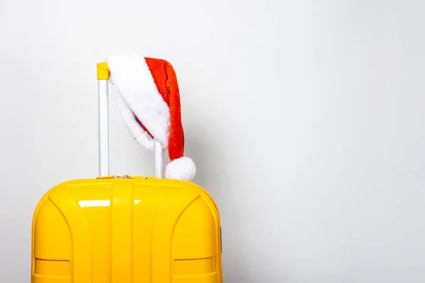 Una Maleta Plástico Amarillo Con Sombrero Rojo Santa Claus Sobre —  Fotos de Stock