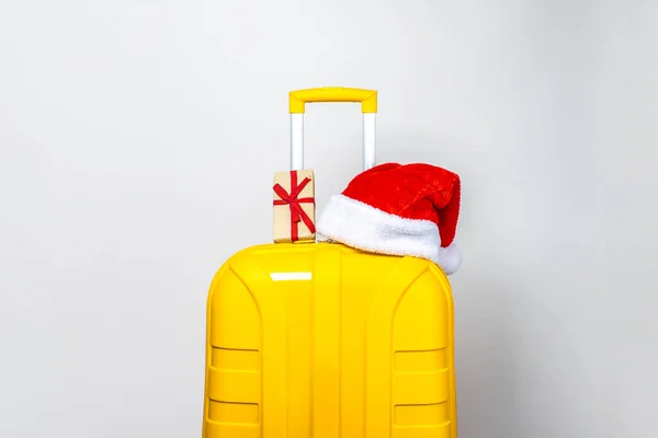 Una Maleta Plástico Amarillo Regalo Lleva Sombrero Santa Claus Rojo — Foto de Stock