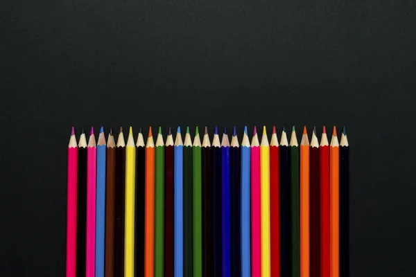 Colored Pencils Lined Up In A Row On A Black Background Flat Lay Top View Yellow Close Stock Photo