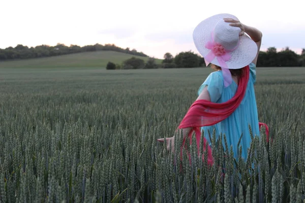 Een Vrouw Met Een Hoed Die Een Veld Loopt — Stockfoto