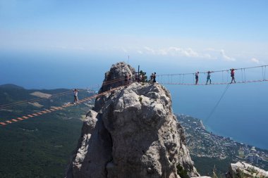 AI - petri yalta blakes ekstrim kablo arabaya yüksekliği boyunca yürüyüş insanlar ile Kırım'ın dağlarında güzel görünür peyzaj