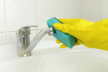 bir musluk su lavabo sünger kumaş mavi eldiven ile temizlik mendili yapan bir erkek eli temiz anlamına gelir.