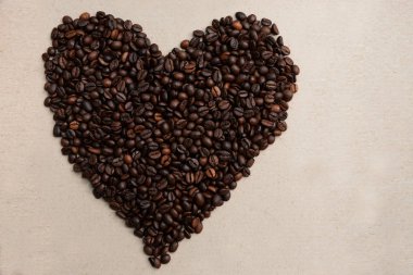 hafif bir arka plan üzerinde bir kalp şeklinde kahve taneleri