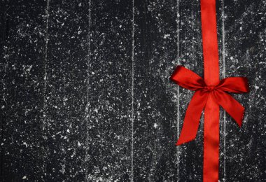 kırmızı yay ahşap arka plan üzerinde bir şerit Tekstil ile bağlı 