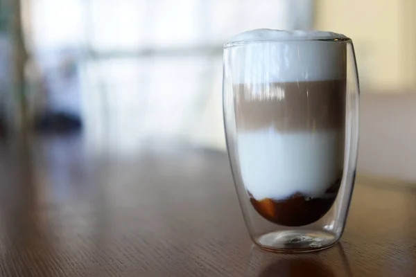 美味的热咖啡与泡沫拿铁与焦糖在一个饭桌上的餐厅的玻璃杯 — 图库照片