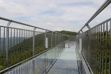 the glass bridge in the Yanoda rain forest park on Hainan Island in the city of Sanya in China clipart