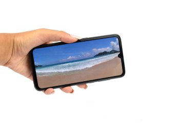 izole beyaz arka plan üzerinde tutan bir kızın elinde bir duvar kağıdı doğa ekran koruyucu ile modern cihaz telefon akıllı telefon siyah