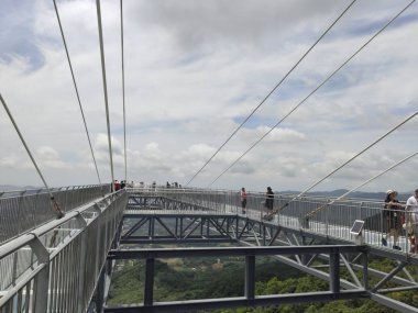 Çin Hainan - Haziran 24, 2019 Çin'de Sanya kentinde Hainan Adası'nda Yanoda yağmur ormanı parkında cam köprü