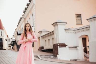 Pembe elbiseli genç, güzel bir kız şehrin güzel sokaklarında yürüyor. Şehirdeki bir kızın çok güzel portreleri..