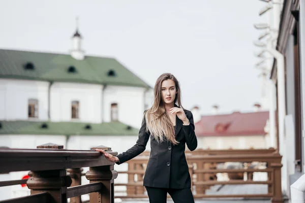 Business girl dans un costume noir sur le fond de la ville — Photo