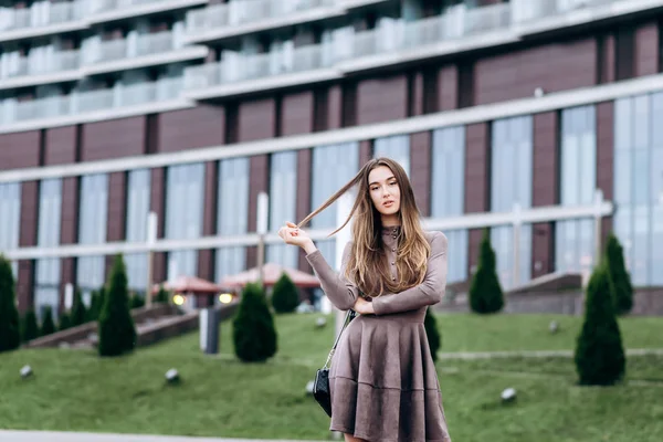 Een jong meisje loopt vlak bij het kantoor met een handtas op haar schouder — Stockfoto