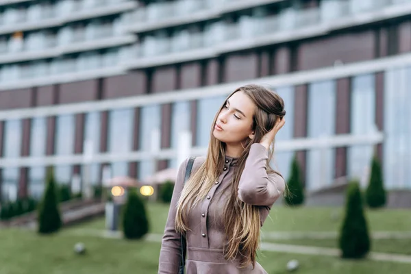 Een jong meisje loopt vlak bij het kantoor met een handtas op haar schouder — Stockfoto