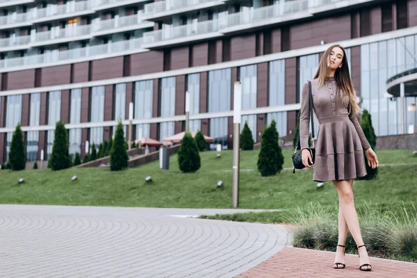 Een jong meisje loopt vlak bij het kantoor met een handtas op haar schouder — Stockfoto