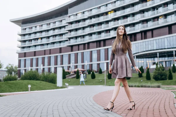 Een jong meisje loopt vlak bij het kantoor met een handtas op haar schouder — Stockfoto