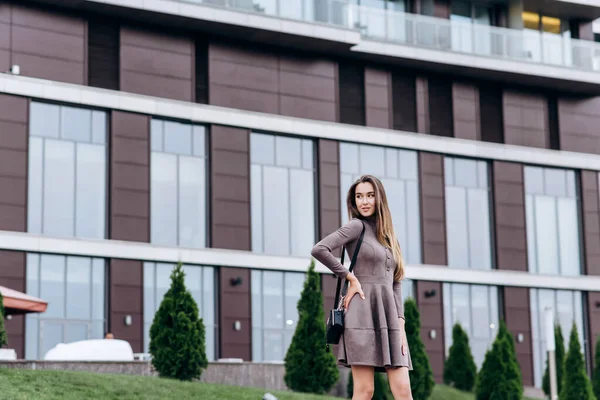 Een jong meisje loopt vlak bij het kantoor met een handtas op haar schouder — Stockfoto