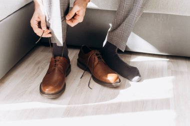 Bir erkek ayakkabı giyer. İşe gidiyorum. Bağcıklarını bağlıyor..