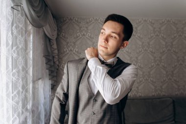 Damat pencerenin yanında duruyor. Düğün günü..