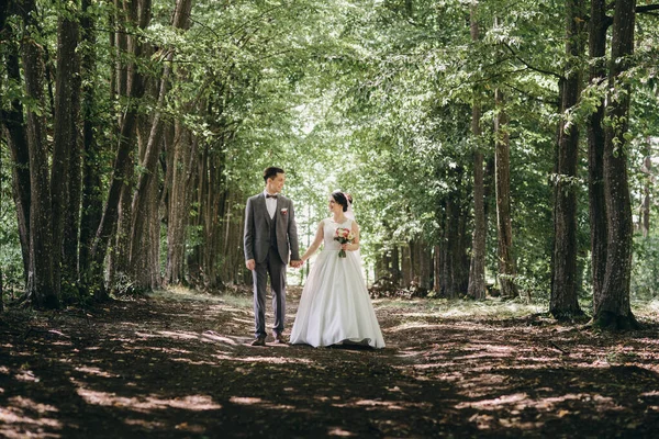 夏の森の中を歩く結婚式。夏の結婚式の写真撮影。新婚夫婦. — ストック写真