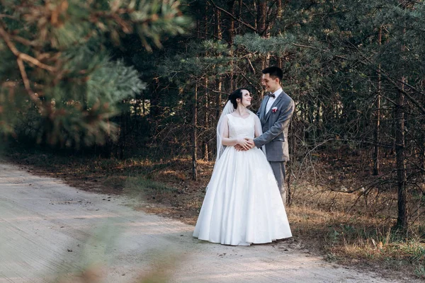 Paseo nupcial en el bosque de verano. Sesión de fotos de boda en verano. Pareja recién casada . — Foto de Stock