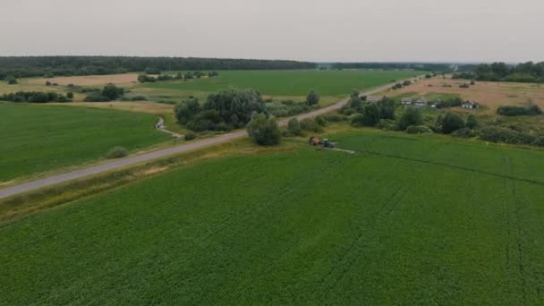 Veld bos trekker dorp genomen uit de lucht — Stockvideo