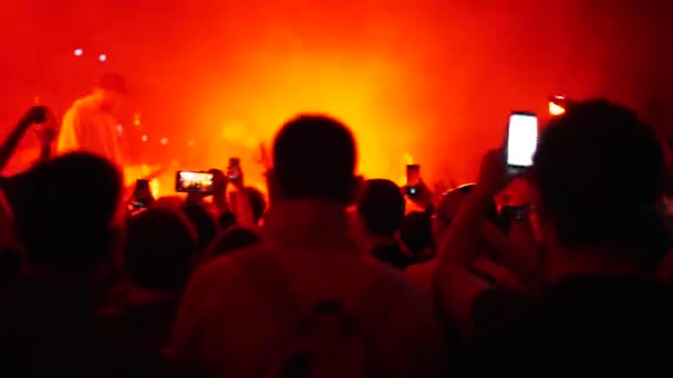 Las espaldas de los espectadores en la contraluz del concierto lumiere — Vídeo de stock