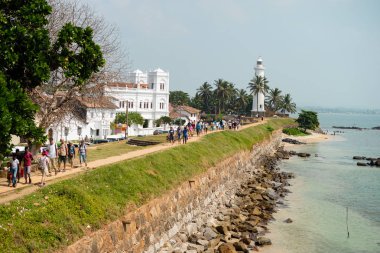 Galle, Sri Lanka-03 Ocak 2019: insanlar ve tuk tuks antik Galle kale içinde belgili tanımlık geçmiş deniz feneri ile içinde bir yolda.