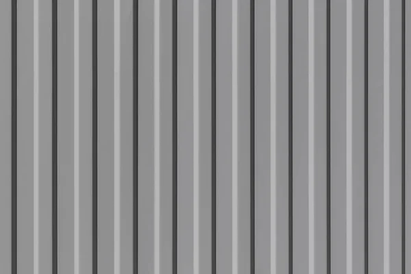 Vlnitý kovový plech vybarvený šedou barvou. Pozadí s hladkým texturou Vlečka. Moderní plot se svislými pruhy. — Stock fotografie