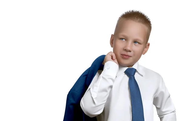 Bello bambino europeo nel personaggio di un uomo d'affari di successo o leader in camicia bianca con una cravatta blu e una giacca sulla spalla, distogliendo lo sguardo dalla fotocamera isolata sul retro biancogr — Foto Stock