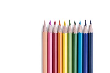 Beyaz arkaplanda izole edilmiş metinler için boş alanı olan gökkuşağı renkleriyle bir sıraya dizilmiş parlak ahşap kalemler. Kırtasiye geçmişi. Sanat ve Eğitim Konsepti