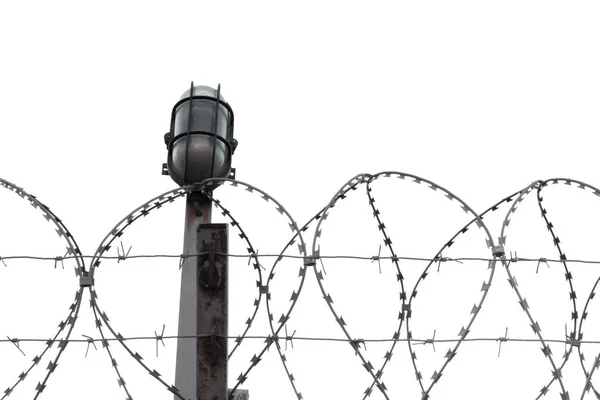 白い背景に孤立した鉄線の縁の間に鉄の柱の上に提灯。テキストのスペースをコピーします。制限区域、軍事基地、刑務所、国境概念 — ストック写真