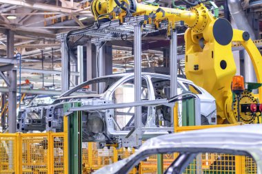 İzhevsk, Rusya - 15 Aralık 2018: hareket halindeki bir platforma montajı için otomatik büyük bir robotik kol manipülatörüyle kaynaklı araç gövdesini kaldırma süreci