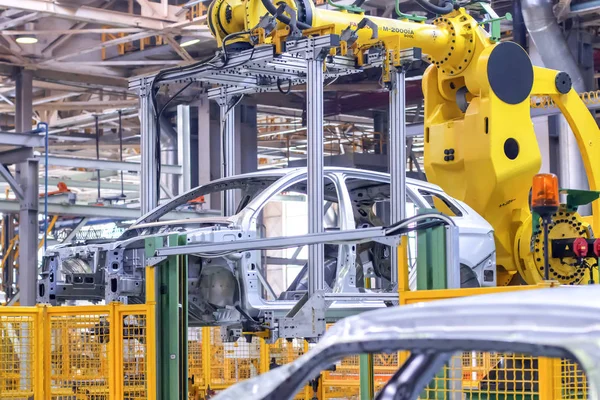 İzhevsk, Rusya - 15 Aralık 2018: hareket halindeki bir platforma montajı için otomatik büyük bir robotik kol manipülatörüyle kaynaklı araç gövdesini kaldırma süreci