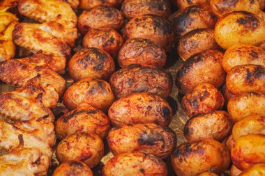 Baharatlı taze fırında patates ve şişte tavuk kanadı. Kömürlü sebzeler. Markette sokak yemeği. Altın hamurlu ızgara patates..