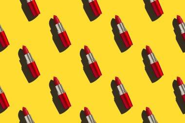 Popüler sanat tarzında arka planda kırmızı ruj ve baskı için fotokopi alanı. Parlak sarı bir arka planda kırmızı ruj. Kusursuz desen. Mükemmel bir rötuşlanmış fotoğraf.