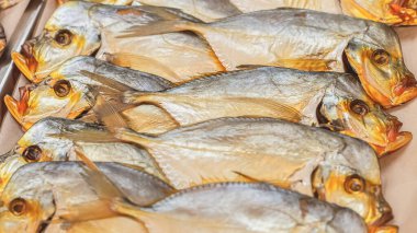 Sokak pazarında hazırlanmış iştah açıcı füme balıklar, tepside iki sıra halinde dizilmiş.