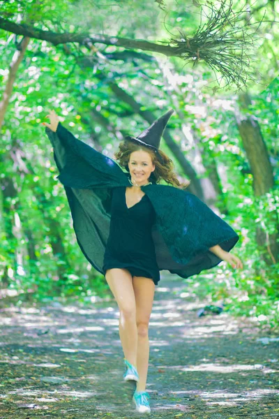 フードの中の妖精と森の中のマント 喜びに満ちた魔女ジャンプしています ハロウィーンの概念 — ストック写真
