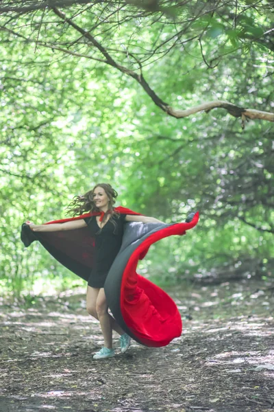 超级英雄晚餐的女人 性感的女孩在红色斗篷 在森林中 跑步时在风中挥舞斗篷 — 图库照片