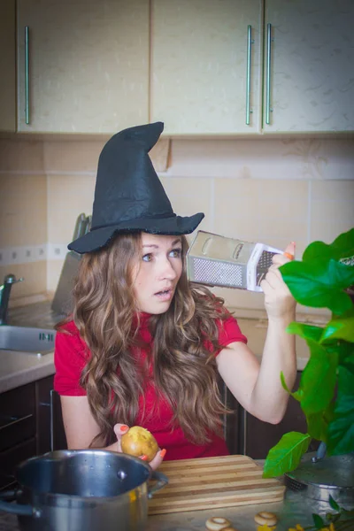 ハロウィーン パーティーの準備をする魔女安息日台所の魔女おろし金を覗き込む 面白い魔女 — ストック写真
