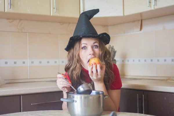 台所で空腹の魔女 ハロウィーン 魅惑的なジャガイモを鍋の上に持っている — ストック写真