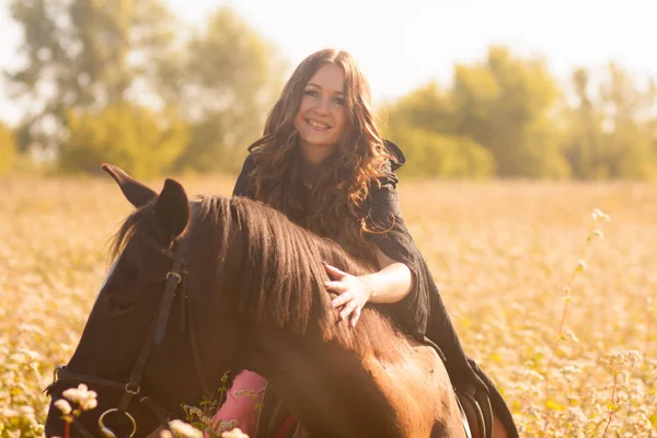 Das Mädchen Reitet Auf Einem Schwarzen Pferd Streichelt Das Pferd — Stockfoto