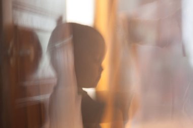 Çocuk pencereden dışarı bakıyor. Bulanık arka plan. çocukluk hayalleri ve rüyalar