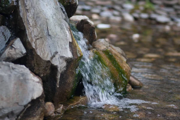 water drains from the stones in the stream stream. photo for your design. sheet horizontal orientation